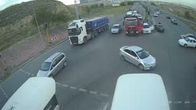 CCTV frame at 0:36 — a white semi-truck with a blue trailer turning through the junction.